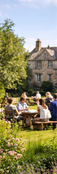 Visitors sitting at picnic tables in the gardens of a heritage venue