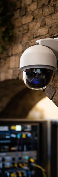 Dome security camera mounted on a stone wall inside a historic building