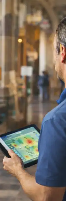 Technician conducting a Wi-Fi site survey inside a historic venue using a tablet
